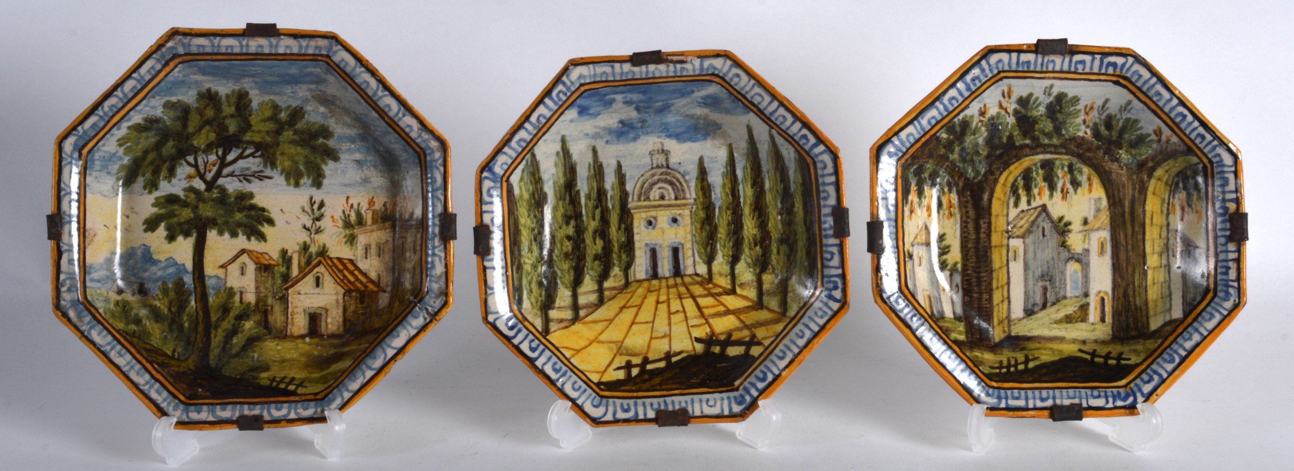 A SET OF THREE 18TH/19TH CENTURY FAIENCE MAJOLICA TYPE OCTAGONAL DISHES painted with buildings