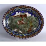 AN EARLY 20TH CENTURY EUROPEAN OVAL SLIP GLAZED OVAL DISH painted with figures walking upon the