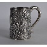 A 19TH CENTURY CHINESE EXPORT SILVER MUG by Luen Wo, decorated in relief with flowering vines, the