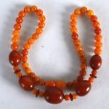 A SMALLER EARLY 20TH CENTURY ORANGE AMBER NECKLACE with various size beads. 15 grams. 1Ft 4iins