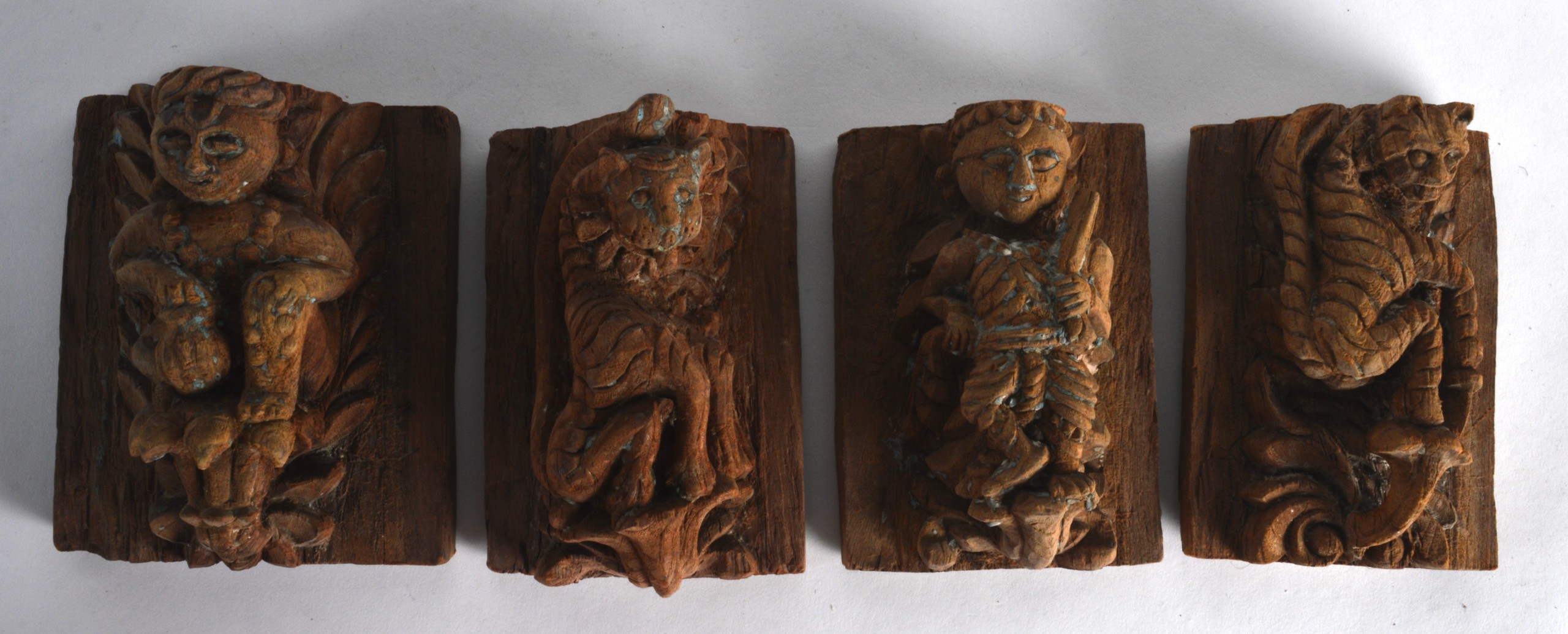 A GROUP OF FOUR 17TH/18TH CENTURY INDIAN CARVED WOODEN TEMPLE PANELS each carved with a figure