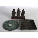 A SET OF THREE CHINESE BRONZE IMMORTALS upon a fitted stand, together with a coin & a square