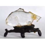 AN EARLY CHINESE CARVED ROCK CRYSTAL FISH upon a hardwood stand. Fish 3.5ins wide.