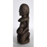 AN AFRICAN CARVED WOOD FERTILITY FIGURE modelled holding a child. 7.25ins high.