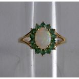 A 9CT GOLD OPAL AND EMERALD RING.