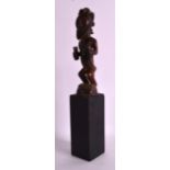 AN AFRICAN CARVED TRIBAL HARDWOOD FIGURE modelled as a bearded male, upon an ebonised column. Figure