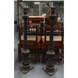 A PAIR OF VICTORIAN CAST IRON LAMPS with scrolling supports.