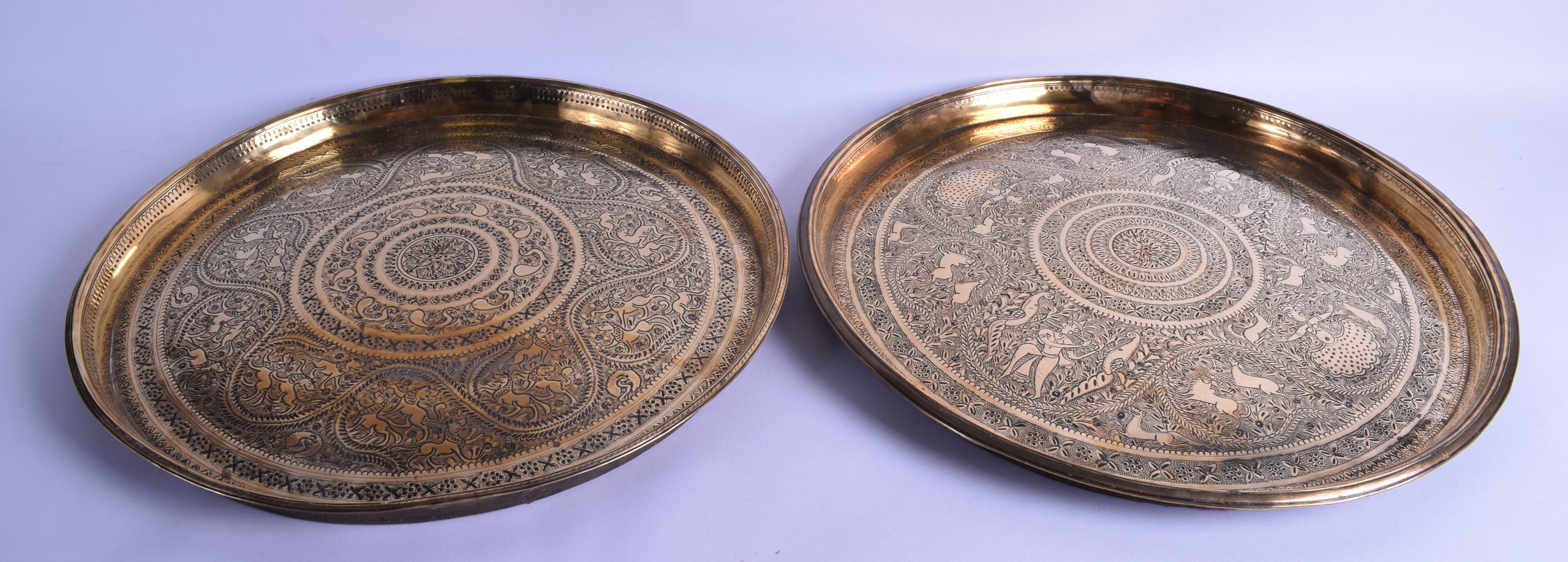 A PAIR OF HEAVY ANTIQUE INDO PERSIAN BRASS DISHES engraved with animals, lions, birds and foliage.