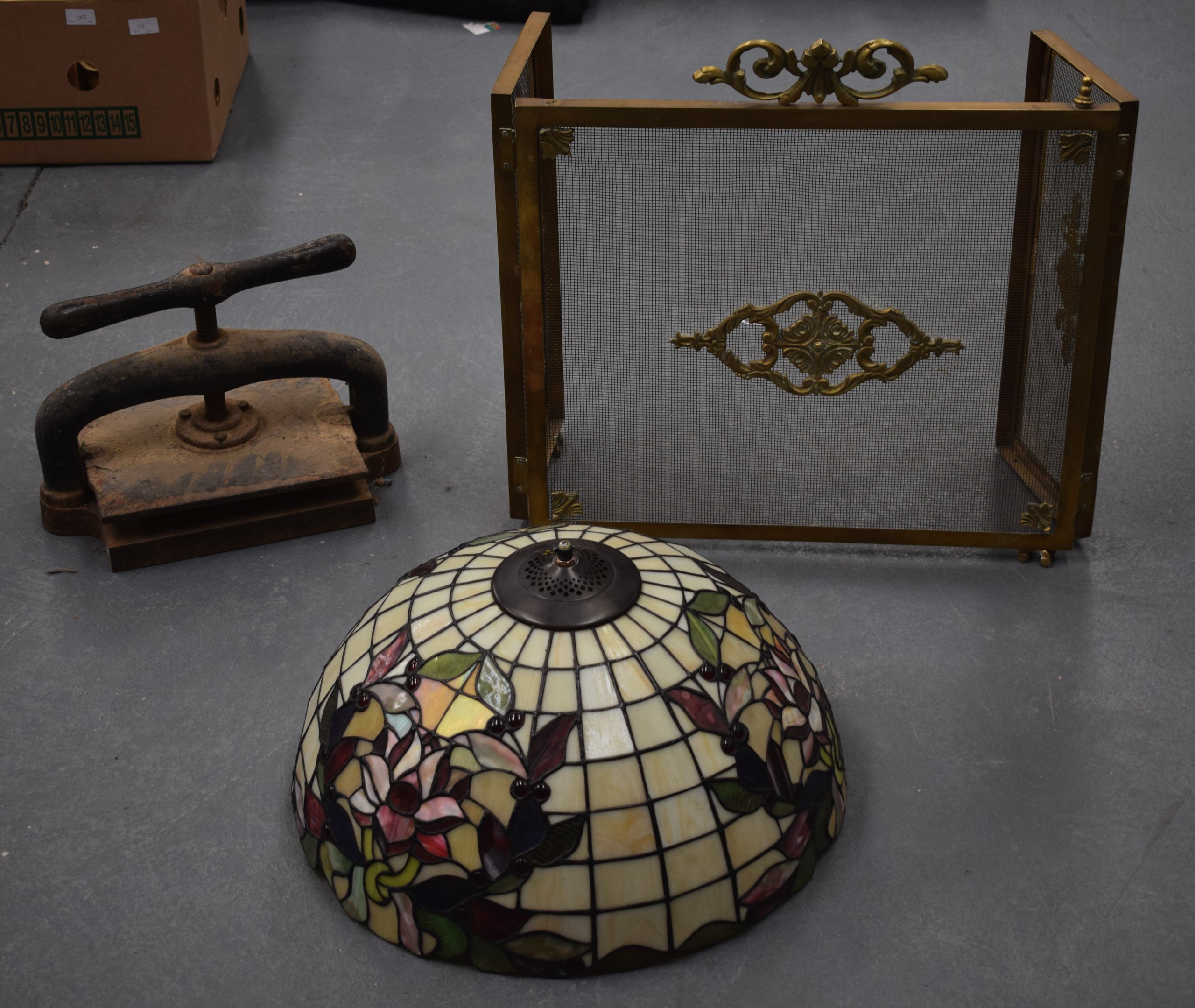 AN ANTIQUE CAST IRON PRESS together with a Victorian fire guard & a Tiffany style lamp shade. (3)