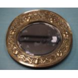 AN ARTS AND CRAFTS EMBOSSED BRASS MIRROR.