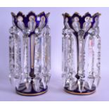A PAIR OF BOHEMIAN BLUE AND CLEAR GLASS TABLE LUSTRES with gilt highlights. 24.5 cm high.
