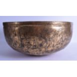 A 12TH CENTURY PERSIAN OR SYRIAN BRASS BOWL engraved with large stylised motifs and floral roundels.