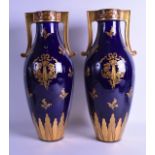 A GOOD LARGE PAIR OF LIMOGES TWIN HANDLED PORCELAIN VASES painted with gilt vines and floral sprigs.