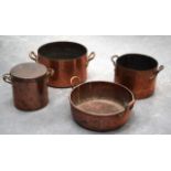 A LARGE VICTORIAN TWIN HANDLED COPPER PAN together with three others. Largest 58 cm diameter. (4)