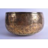 A 12TH CENTURY PERSIAN OR SYRIAN BRASS BOWL engraved with calligraphy and motifs. 29 cm x 19 cm.