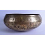 A 12TH CENTURY PERSIAN OR SYRIAN BRASS BOWL engraved with calligraphy , foliage and panels of