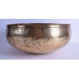 A 12TH CENTURY PERSIAN OR SYRIAN BRASS BOWL engraved with calligraphy and angular motifs. 36 cm x 18