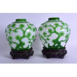 A PAIR OF EARLY 20TH CENTURY CHINESE PEKING GLASS GINGER JARS carved with extensive foliage and