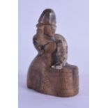 AN UNUSUAL 19TH CENTURY INUIT CARVED SOAPSTONE FIGURE OF A MALE modelled holding a fish. 9.5 cm