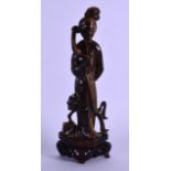 AN EARLY 20TH CENTURY CHINESE CARVED TIGERS EYE FIGURE OF GUANYIN modelled holding a floral sprig