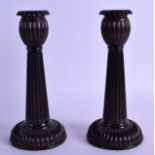 A STYLISH PAIR OF EARLY 20TH CENTURY AFRICAN BLACKWOOD CANDLESTICKS with finely carved bases and