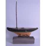 AN ANTIQUE GREEN PAINTED WOODEN POND YAUCHT upon a later painted plinth. 52 cm x 65 cm.