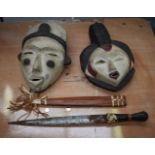 A PAIR OF AFRICAN POLYCHROMED MASKS together with a North African dagger. (3)