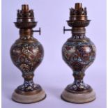 A PAIR OF 19TH CENTURY FRENCH CHAMPLEVE ENAMEL OIL LAMPS decorated with extensive foliage. 23 cm