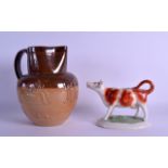 A 19TH CENTURY DOULTON LAMBETH STONEWARE JUG together with a Staffordshire cow creamer. Jug 20 cm