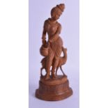 AN EARLY 20TH CENTURY INDIAN CARVED SANDALWOOD FIGURE OF A FEMALE modelled standing beside a deer.