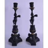 A PAIR OF 19TH CENTURY BLACK PAINTED BRONZE CANDLESTICKS modelled as a nude putti pouring a jug.