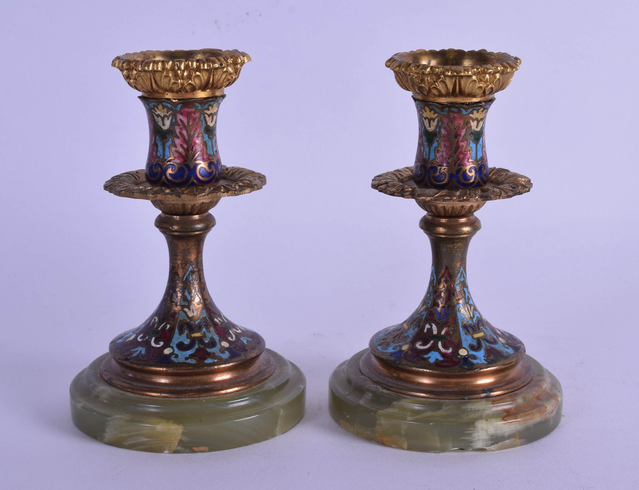 A PAIR OF 19TH CENTURY FRENCH CHAMPLEVE ENAMEL ONYX DWARF CANDLESTICKS decorated with foliage and