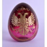 AN UNUSUAL RUSSIAN CARVED AND PAINTED GILT EGG decorated with two opposing birds and scrolling