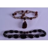 TWO EARLY 20TH CENTURY CARVED RED AMBER NECKLACE. 38 grams & 18 grams. (2)