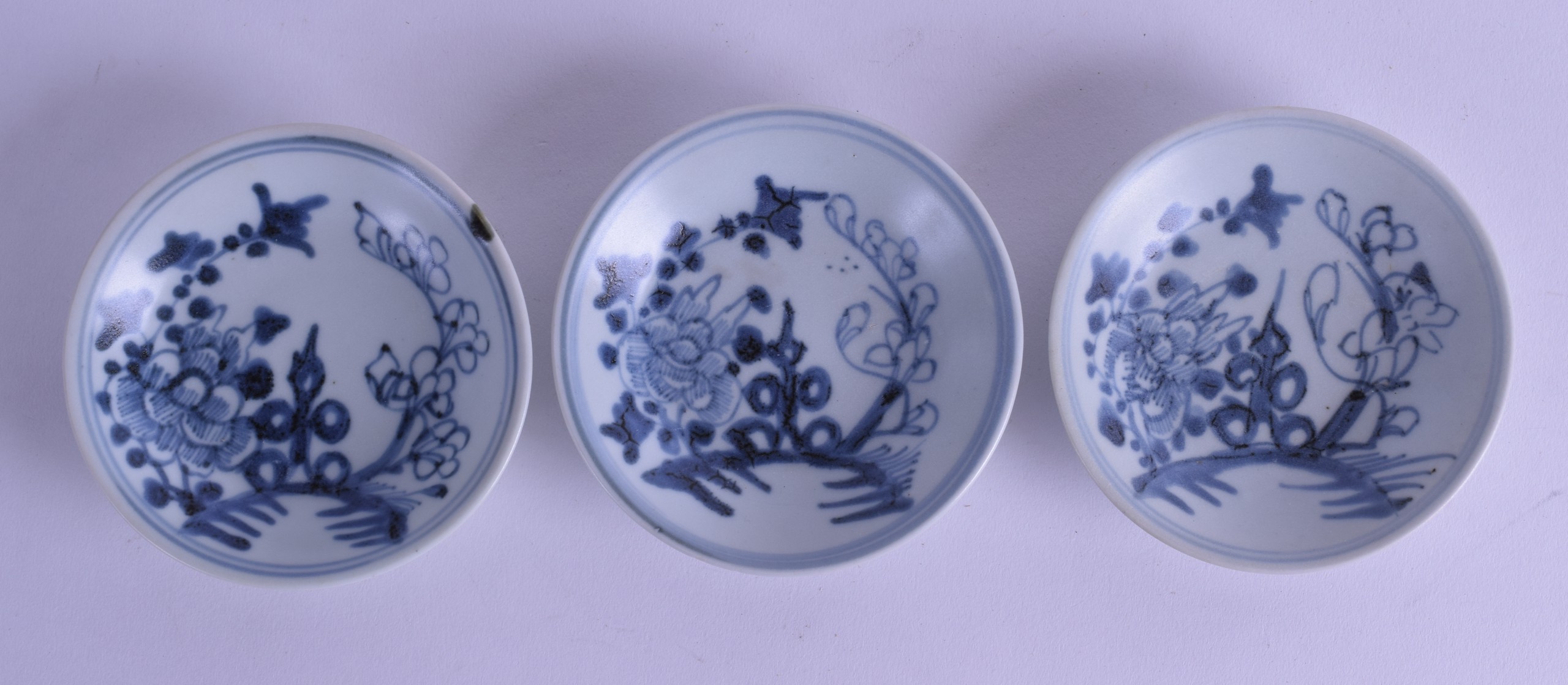 A SET OF THREE CHINESE TEK SING CARGO SAUCERS painted with flowers. 9.5 cm diameter. (3)