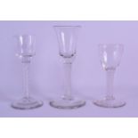 A GROUP OF THREE GEORGE III GLASSES each with white spiral twist stems. Largest 17 cm high. (3)