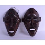 A PAIR OF AFRICAN CARVED WOOD TRIBAL MASKS with angular incised decoration. 15 cm x 23 cm.