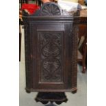 A 19TH CENTURY OAK CORNER CUPBOARD, carved with foliage. 3 ft 6ins long.