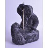 A LARGE CANADIAN NAVUK CARVED SOAPSTONE FIGURE OF INUIT ESKIMO SEAL HUNTER modelled stabbing a