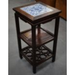 A 19TH CENTURY CHINESE CARVED HARDWOOD OCCASIONAL TABLE inset with a blue and white square porcelain