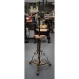 AN EDWARDIAN BRASS STANDARD LAMP of scrolling form.