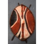 A LARGE EARLY 20TH CENTURY PAINTED AFRICAN HIDE SHIELD probably Zulu, with crossed swords to