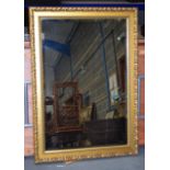 A SCROLLING GILT MIRROR. 74 cm x 107 cm.