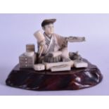 A GOOD 19TH CENTURY JAPANESE MEIJI PERIOD CARVED IVORY OKIMONO modelled as an artisan holding a