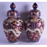 A LARGE PAIR OF 19TH CENTURY JAPANESE MEIJI PERIOD IMARI VASES AND COVERS unusually decorated with a