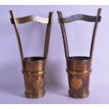 A PAIR OF ARTS AND CRAFTS BRASS WINE HOLDERS decorated with stylised roundels. 33 cm high.