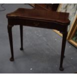 AN EDWARDIAN MAHOGANY FOLD OVER CARD TABLE with baize lined interior.