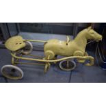 A LARGE EARLY 20TH CENTURY PAINTED METAL CHILDS RIDE ALONG TOY in the form of a horse. 107 cm long.