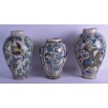 A SET OF THREE EARLY 20TH CENTURY PERSIAN POTTERY VASES painted with flowers and birds. Largest 34