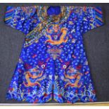 A 19TH CENTURY CHINESE BLUE SILKWORK DRAGON ROBE decorated with stylised gold thread dragons amongst